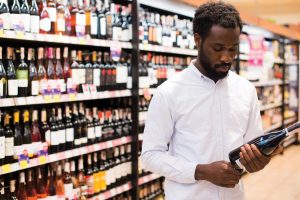 man choosing bottle wine alcohol section